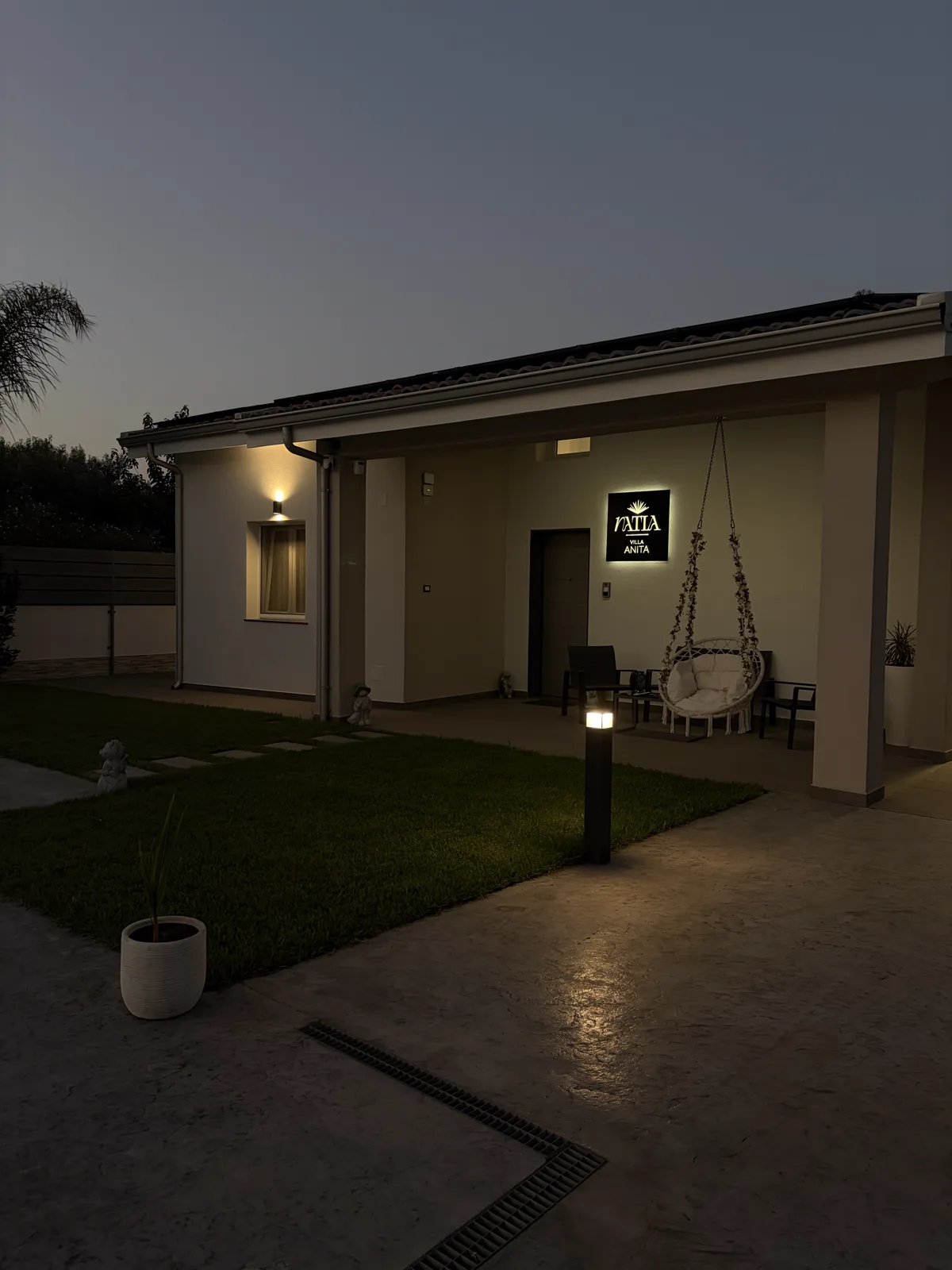 Villa Natìa — esterno al tramonto con insegna illuminata